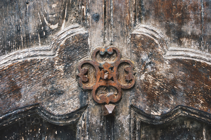 Rusted door ornament on carved wood door