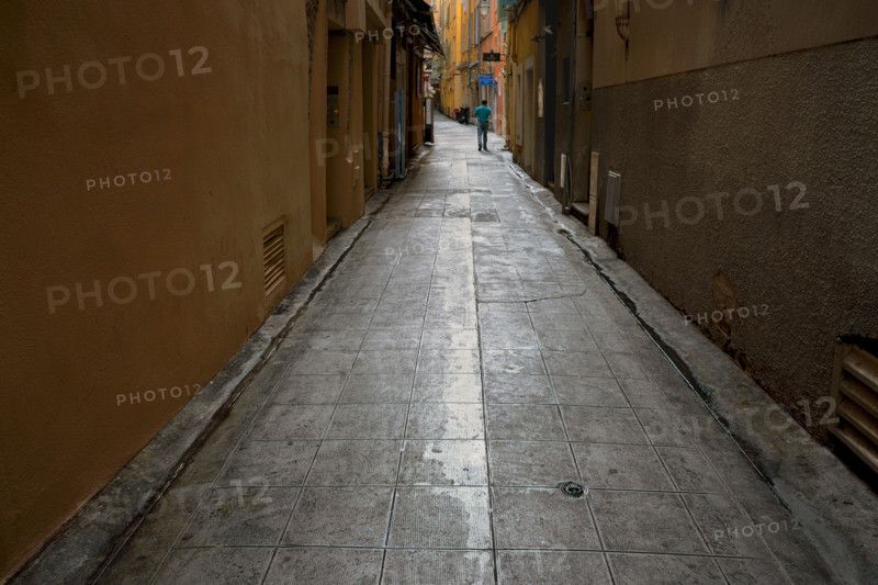 Rear view of man walking through alley, Vieux Nice, Nice, France