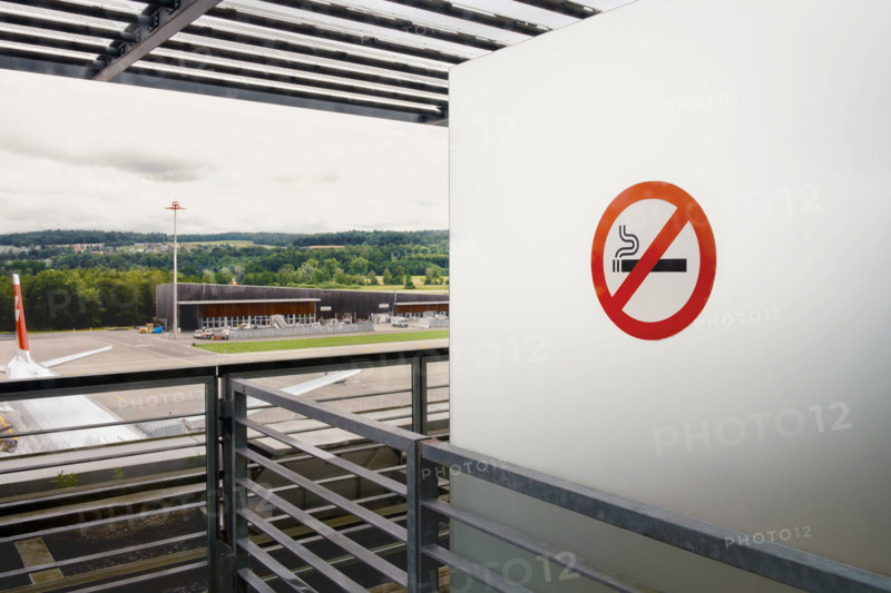 No smoking sign on white wall at airport, Zurich, Switzerland