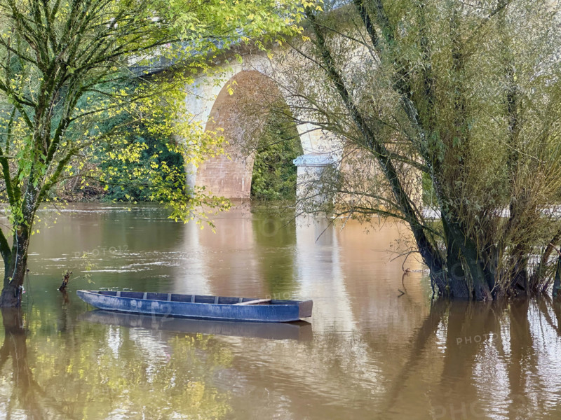 Blue rowboat on river, Dordogne, France