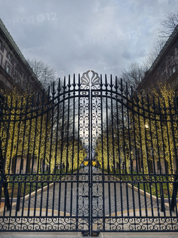 Entrance Gate at College Walk at dusk with illuminated lights wrapped around trees, Columbia University, New York City, New York, USA
