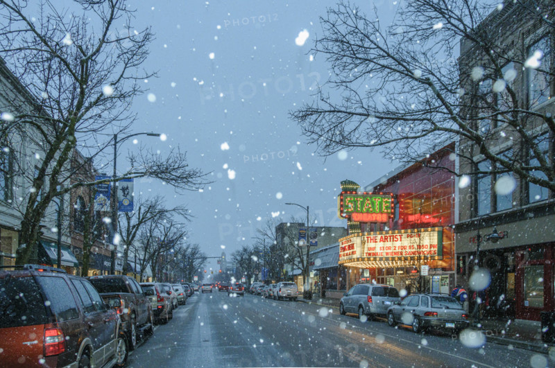 Snowy street scene with illuminated movie theater marquee, Traverse City, Michigan, USA