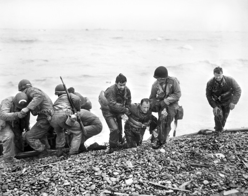 Surviving members of American landing party, whose landing craft was sunk by enemy action, reaching Utah Beach by using life raft, near Cherbourg, Normandy, France, U.S. Army Signal Corps, June 6, 1944