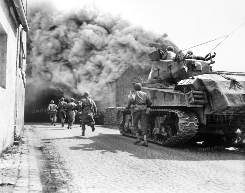 U.S. soldiers of 55th Armored Infantry Battalion and tank of the 22nd Tank Battalion, moving through smoke filled street, Wernberg, Germany, U.S. Army Signal Corps, April 22, 1945