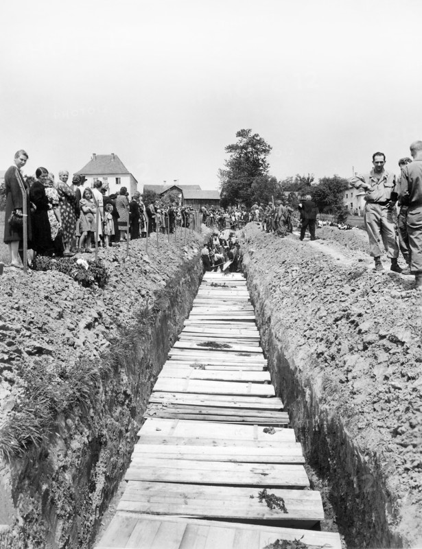 Civilians giving burial to 800 victims of SS killing. which was ordered by the military government after bodies were laying in open for five days, Nammering, Germany, U.S. Army Signal Corps, May 19, 1945