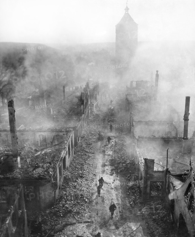 U.S. infantrymen of the 255th Infantry Regiment moving down street to hunt out Hun after recent raid by U.S. 63rd Division, Waldenburg, Germany, U.S. Army Signal Corps, April 16, 1945