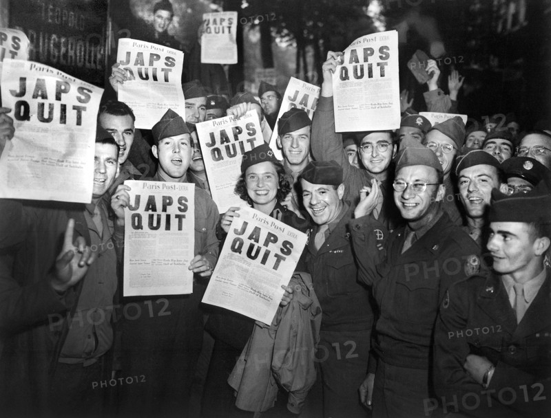 GI's at Rainbow Corner Red Cross Club celebrating after buying special edition of Paris Post newspaper, Paris, France, U.S. Army Signal Corps, August 10, 1945