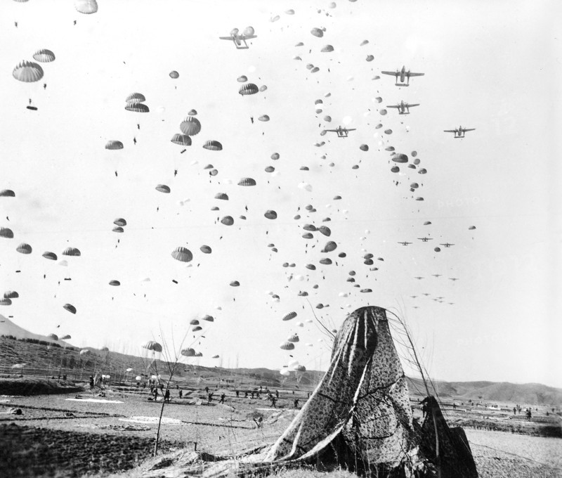 Paratroopers of the 187th RCT [Regimental Combat Team] floating earthward from C-119's to cut off retreating enemy units south of Munsan, Korea, U.S. Army Signal Corps, March 23, 1951
