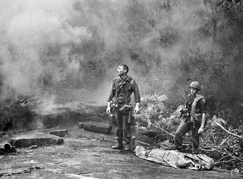 SP4 R. Richter, 4th Battalion, 503rd Infan1try, 173rd Airborne Brigade with Sergeant Daniel E. Spencer as they await helicopter to transport fallen comrade, Long Khanh Province, Republic of Vietnam, U.S. Army Signal Corps, 1966