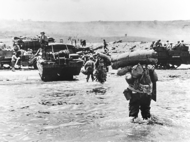 American assault troops with full amphibious military equipment moving onto Omaha Beach, Colleville-sur-Mer, Normandy, France, U.S. Army Signal Corps, June 6, 1944