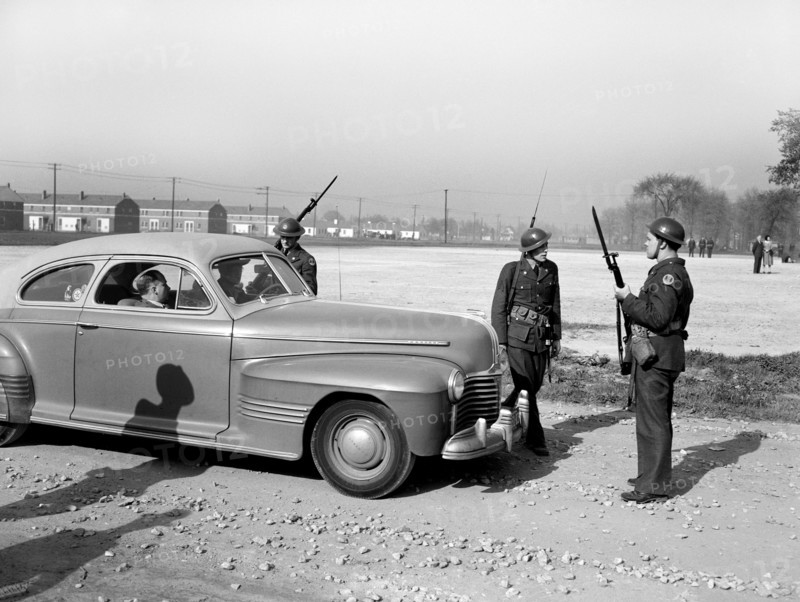 Home guard troops with bared bayonets preventing cars from entering Sojourner Truth Homes, a U.S. Federal Housing Project, during riot caused by white neighbors' attempting to prevent black tenants from moving in, Detroit, Michigan, USA, Arthur S. Siegel, U.S. Office of War Information, February 1942