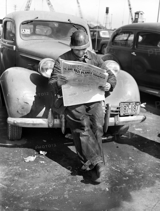 Factory worker reading newspaper while on break, Bethlehem-Fairfield shipyards, Baltimore, Maryland, USA, Arthur S. Siegel, U.S. Office of War Information, May 1943