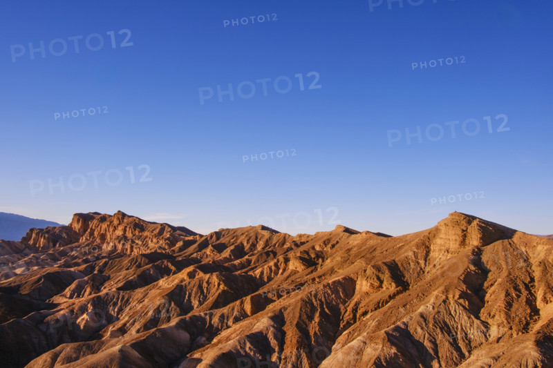 Hikers in distance along crest of Red Cathedral Trail near Zabriskie Point, Death Valley National Park, California, USA