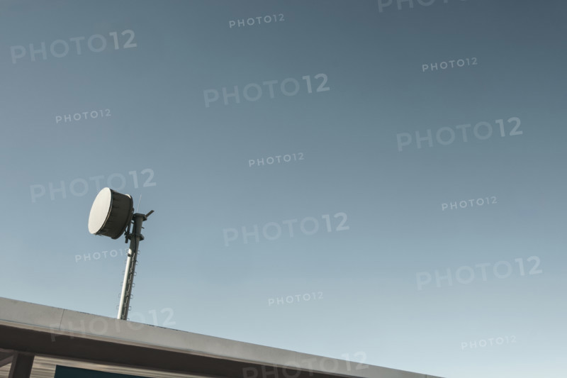 Microwave transmitter mounted to the roof against blue sky