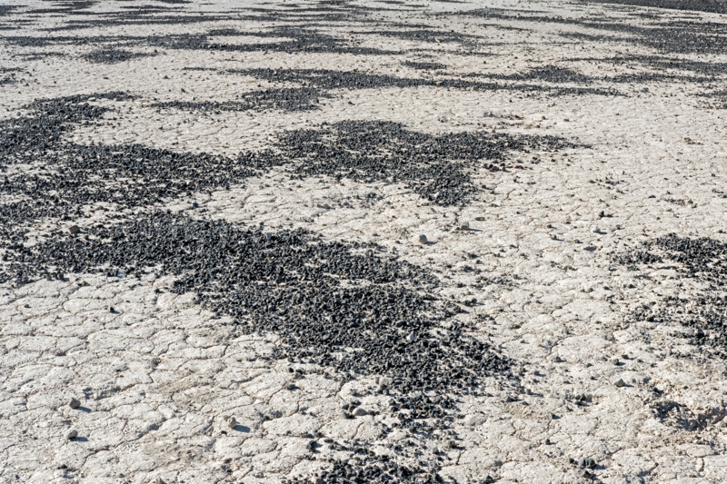 Scattered cinders from volcanic steam explosion on dried lake bed, Death Valley National Park, California, USA