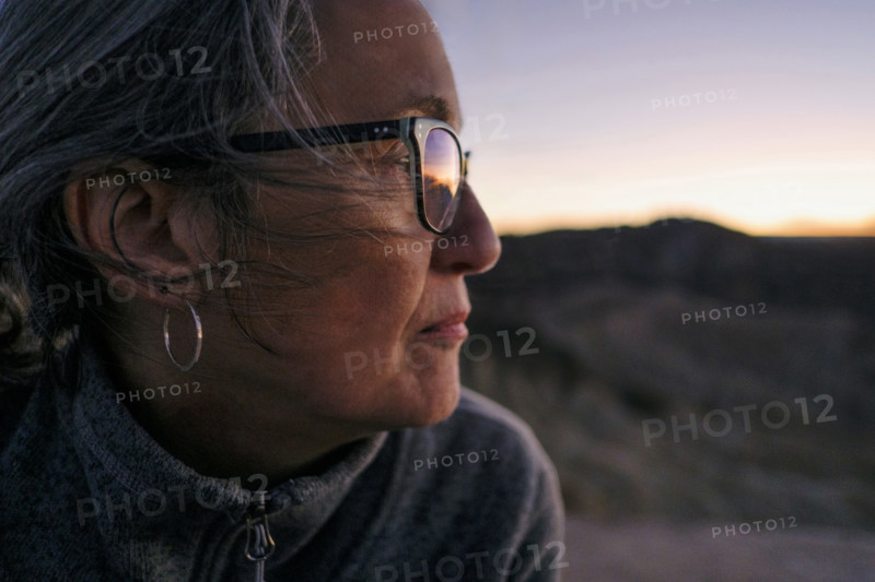 Head shoulders profile of senior adult woman looking at sunset, Zabriskie Point, Death Valley, California, USA