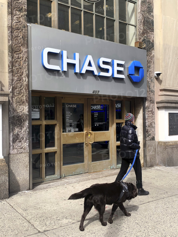 Chase Bank retail branch, building exterior and sidewalk scene with woman walking a dog, New York City, New York, USA