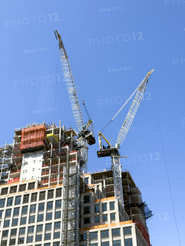 Construction cranes atop new residential building under construction, New York City, New York, USA