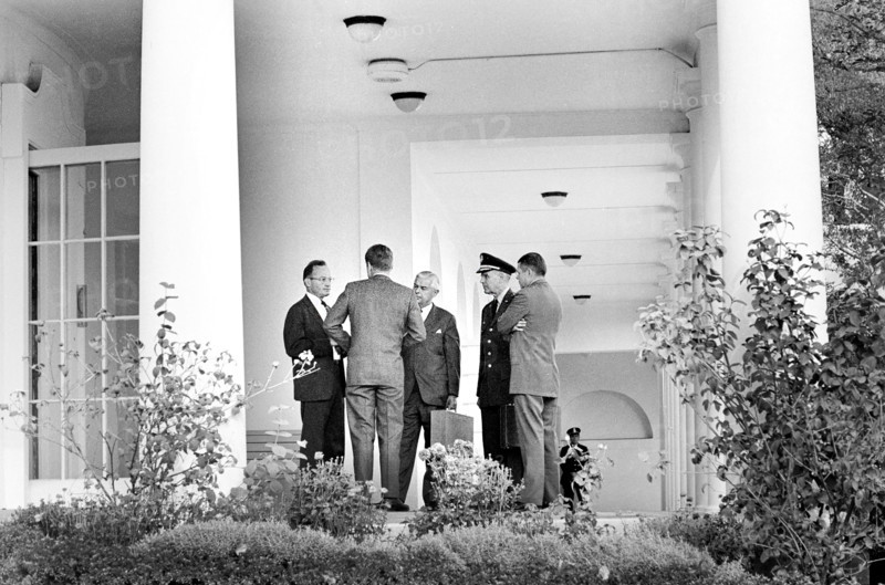 U.S. President John F. Kennedy (back view) speaking with (L-R) Special Assistant to the President for National Security McGeorge Bundy, Assistant Secretary of Defense for International Security Affairs Paul Nitze, Chairman of the Joint Chiefs of Staff General Maxwell D. Taylor, and Secretary of Defense Robert S. McNamara in the West Wing Colonnade outside the Oval Office during meeting with the Executive Committee of the National Security Council that day regarding the crisis in Cuba, White House, Washington, D.C., USA, Cecil W. Stoughton, White House Photographs, October 29, 1962