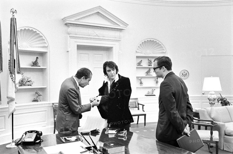U.S. President Richard Nixon meeting with Elvis Presley during open hour in the Oval Office with assistant Egil Krogh standing nearby, White House, Washington, D.C., USA, White House Photo Office, December 21, 1970