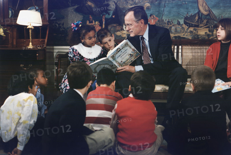 U.S. President George H.W. Bush reading a book to children during Great American Read Aloud Day, Diplomatic Reception Room, White House, Washington, D.C., USA, David Valdez, White House photographer, April 16, 1991