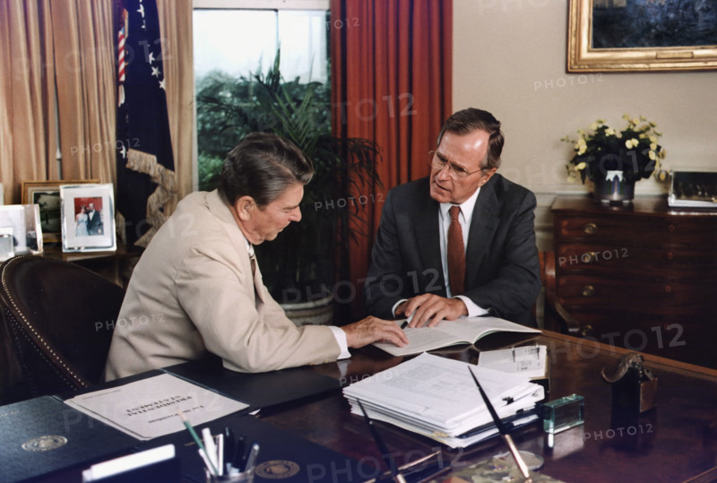 U.S. President Ronald Reagan and U.S. Vice President George H.W. Bush working in the Oval Office, White House, Washington, D.C., USA, David Valdez, White House photographer, July 20, 1984