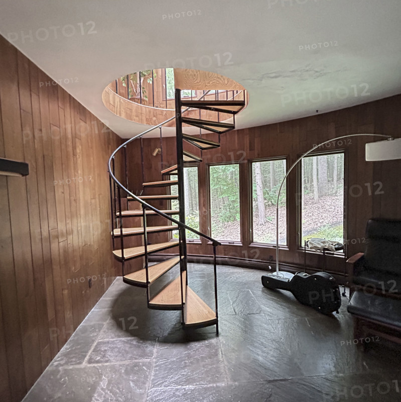 Spiral staircase in wood paneled room in residential home