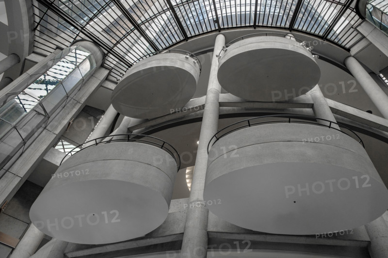 Low angle view of four oval balconies and skylight in hotel lobby