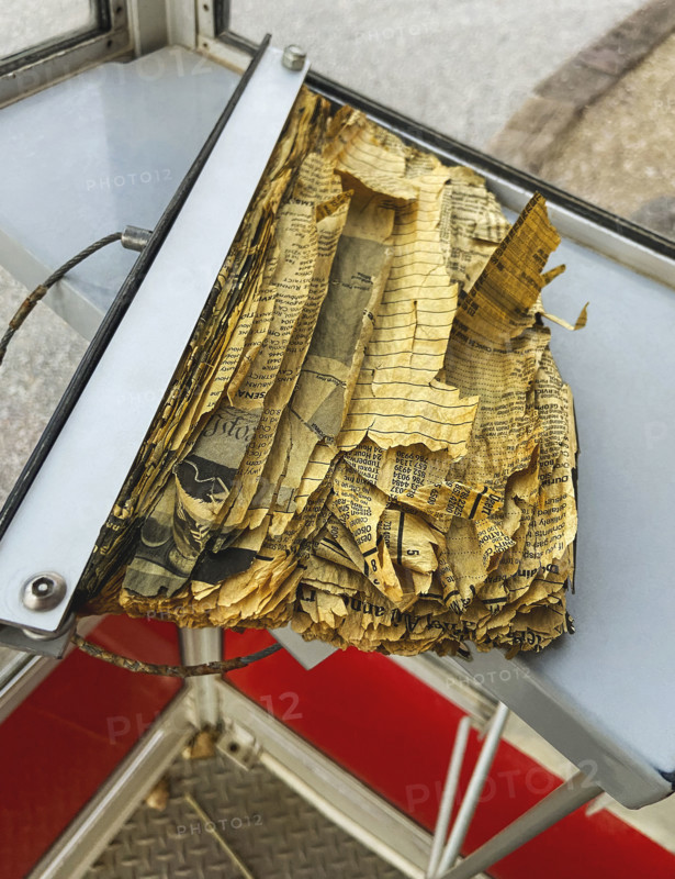 Tattered and torn phone book inside old telephone booth
