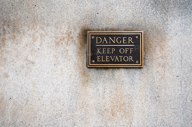 Bronze warning sign mounted on office building
