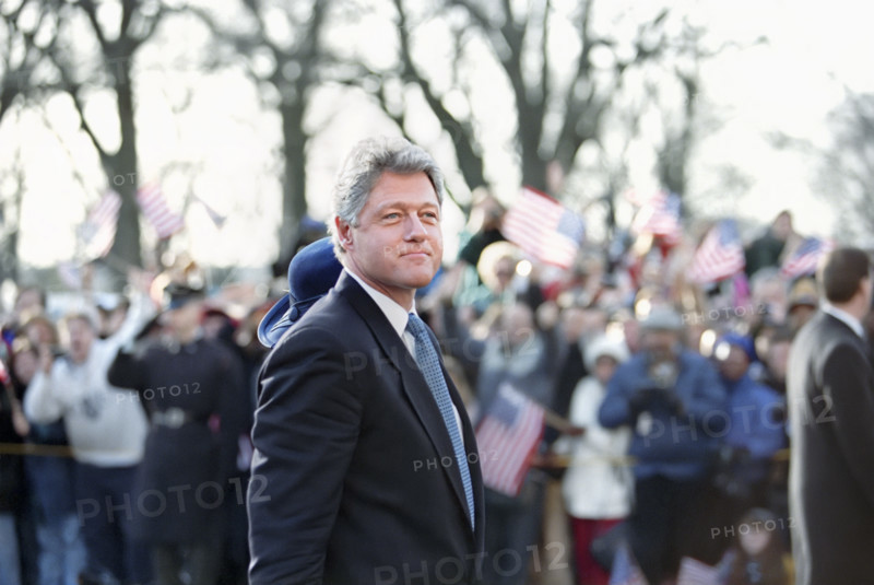 U.S. President Bill Clinton and U.S. First Lady Hillary Rodham Clinton (mostly hidden with blue hat) walking along the Inaugural Parade route and waving to the crowd, Washington, D.C., USA, Bob McNeely, White House Photographer, January 20, 1993