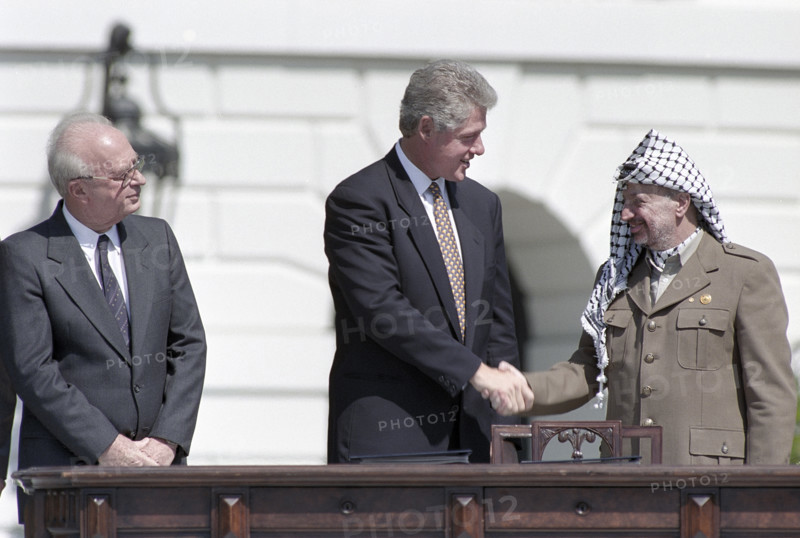 U.S. President Bill Clinton shaking hands with Palestine Liberation Organization Chairman Yasser Arafat as Israeli Prime Minister Yitzhak Rabin looks on during ceremony for Middle East Peace agreement signing, South Lawn of White House, Washington, D.C., USA, Vince Musi, White House Photographer, September 13, 1993