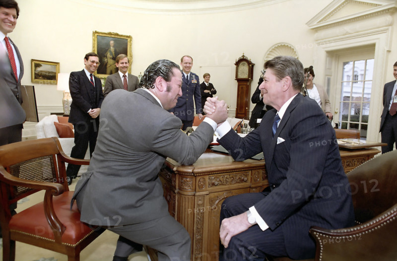 U.S. President Ronald Reagan arm wrestling Dan Lurie of Muscle Training magazine in Oval Office of the White House, Washington, D.C., USA, President Ronald Reagan White House Photographic Office, February 16, 1984