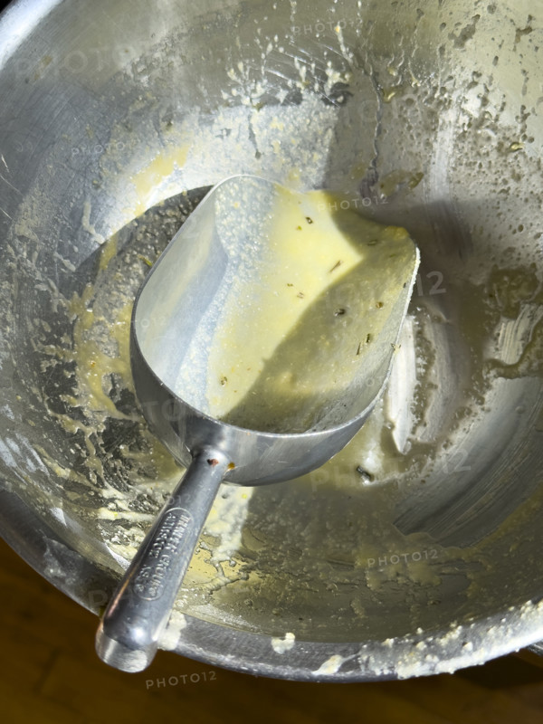 High angle view of metal bowl and scoop used to mix cornbread
