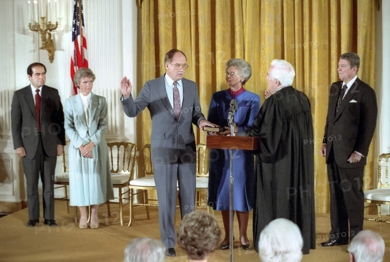 U.S. President Ronald Reagan watching swearing-In ceremony for Chief Justice William Rehnquist by Chief Justice Warren Burger in the White House East Room, Washington, D.C., USA, President Ronald Reagan White House Photographic Office, September 26, 1986
