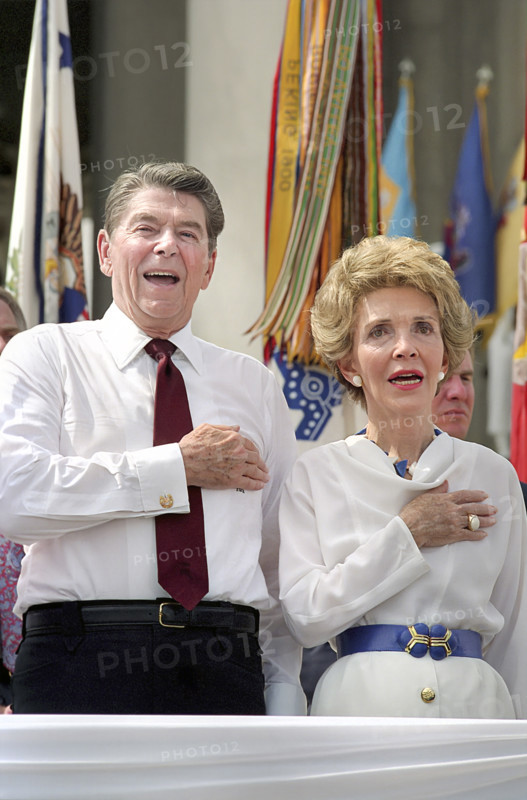 U.S. President Ronald Reagan and U.S. First Lady Nancy Reagan singing U.S. National Anthem while placing hands over their hearts at The Star Spangled Salute to America, Jefferson Memorial, Washington, D.C., USA, President Ronald Reagan White House Photographic Office, July 3, 1987