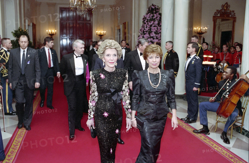 U.S. First Lady Nancy Reagan walking with First Lady of the Soviet Union Raisa Gorbachev in White House Cross Hall before State Dinner, Washington, D.C., USA, President Ronald Reagan White House Photographic Office, December 8, 1987