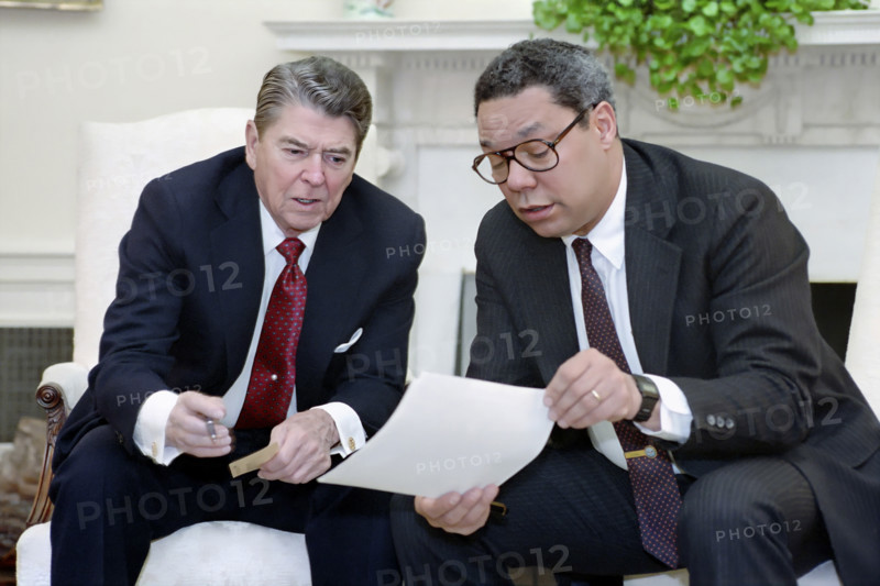 U.S. President Ronald Reagan holding a National Security Council meeting on the Persian Gulf with National Security Advisor Colin Powell, White House Oval Office, Washington, D.C., USA, President Ronald Reagan White House Photographic Office, April 18, 1988