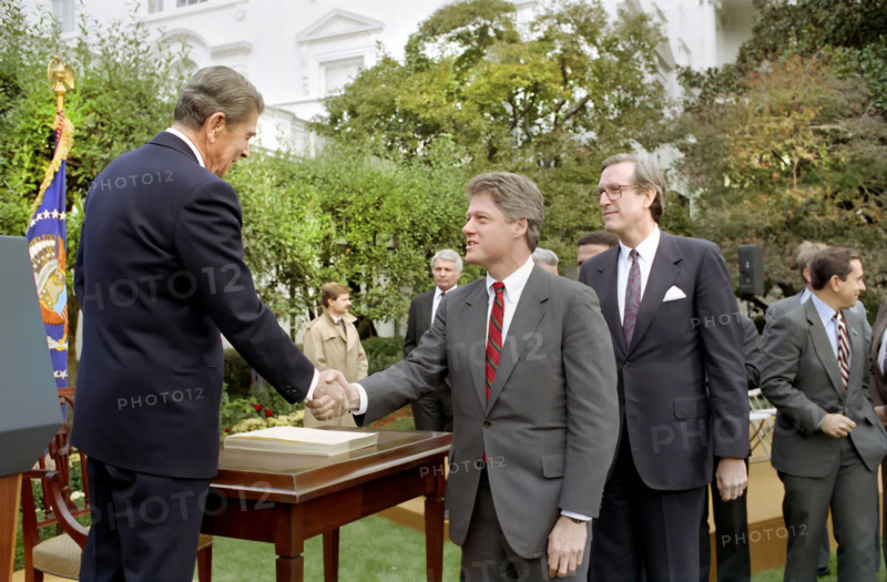 U.S. President Ronald Reagan shaking hands with Arkansas Governor Bill Clinton after signing the Family Support Act in the White House Rose Garden, Washington, D.C., USA, President Ronald Reagan White House Photographic Office, October 13, 1988