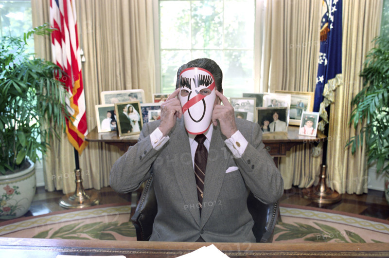 U.S. President Ronald Reagan wearing an anti-Michael Dukakis mask in the White House Oval Office, Washington, D.C., USA, President Ronald Reagan White House Photographic Office, October 14, 1988