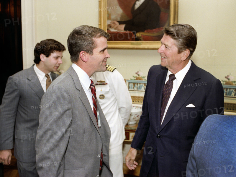 U.S. President Ronald Reagan greeting Oliver North during ceremony to present Medal of Freedom to Ambassador Philip Habib, White House Blue Room, Washington, D.C., USA, President Ronald Reagan White House Photographic Office, September 7, 1982