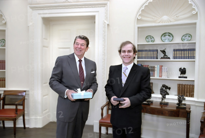 U.S. President Ronald Reagan with British musician Elton John in White House Oval Office, Washington, D.C., USA, President Ronald Reagan White House Photographic Office, August 4, 1982