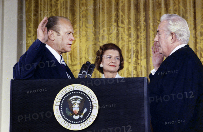 U.S. Supreme Court Chief Justice Warren Burger administering oath of office to U.S. President Gerald Ford while U.S. First Lady Betty Ford looks on, White House East Room, Washington, D.C., USA, Gerald R. Ford White House Photographs, August 9, 1974
