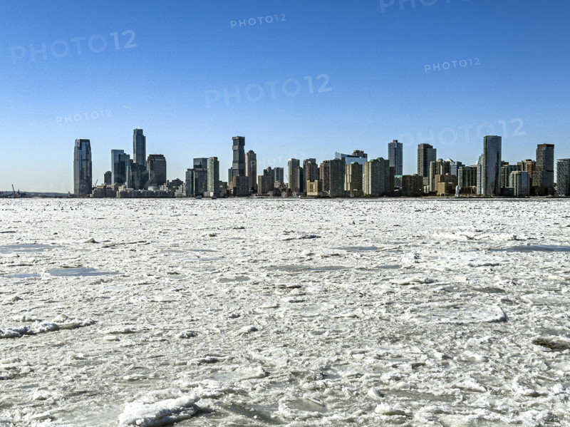 View of Jersey City, New Jersey, USA skyline across frozen Hudson River