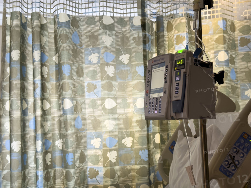 Empty hospital bed in patient room with medical equipment
