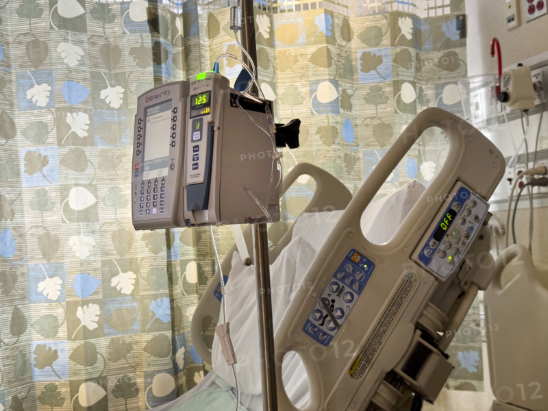 Empty hospital bed in patient room with medical equipment