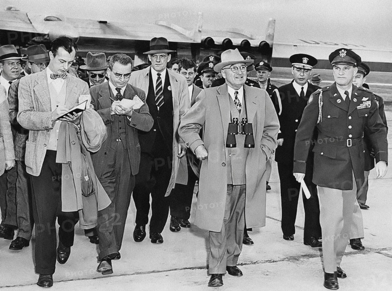 U.S. President Harry S. Truman (center, with binoculars) is followed by unknown reporters while attending Air Progress Demonstration. Also with President Truman is General Robert B. Landry (far right), and Admiral Robert L. Dennison (behind Landry), Andrews Air Force Base, Prince George's County, Maryland, USA, Abbie Rowe, National Parks Service, Harry S. Truman Library, February 15, 1949