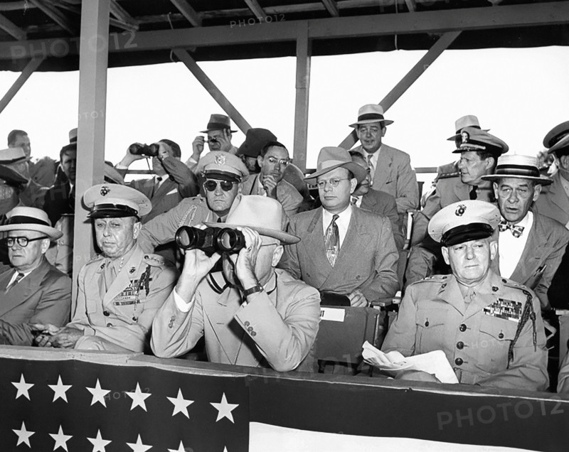 U.S. President Harry S. Truman peering through binoculars, with other dignitaries, watching weapons demonstration involving amphibious helicopter landings, United States Marine base at Quantico, Virginia, USA, Abbie Rowe, National Parks Service, Harry S. Truman Library, June 15, 1950