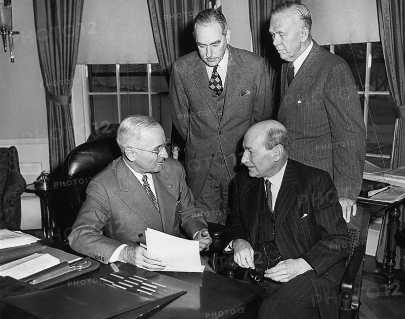 British Prime Minister Clement Attlee (seated right) meeting with President Harry S. Truman (seated left), U.S. Secretary of State Dean Acheson (standing left) and U.S. Secretary of Defense George C. Marshall (standing right) in White House Oval Office, Washington, D.C., USA, Abbie Rowe, National Parks Service, Harry S. Truman Library, December 4, 1950