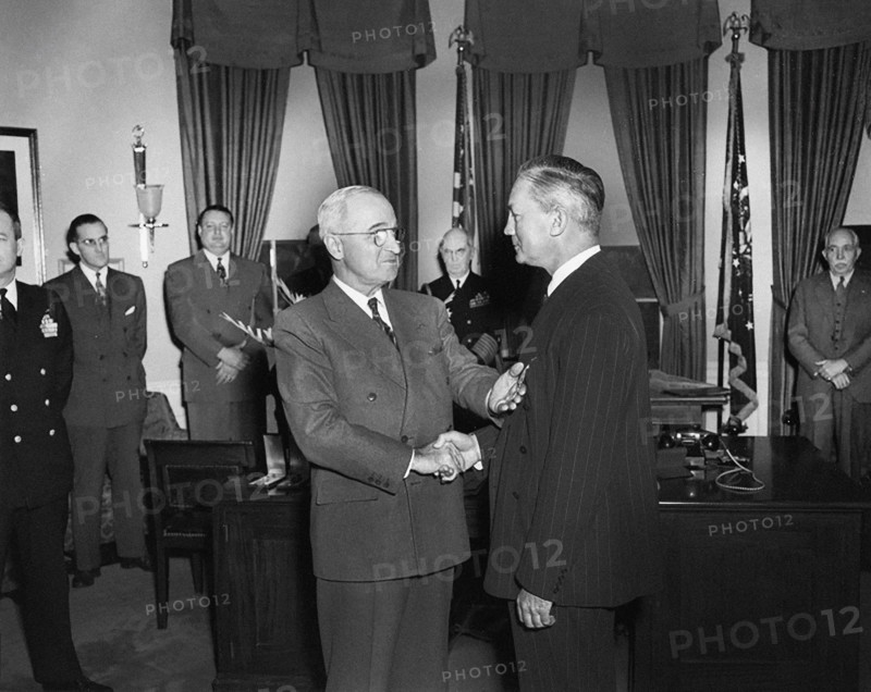 U.S. President Harry S. Truman (left) presenting Medal of Merit to U.S. Secretary of Defense James Forrestal (right) in the White House Oval Office, Washington, D.C., USA, Abbie Rowe, National Parks Service, Harry S. Truman Library, January 27, 1948